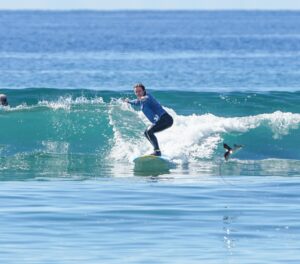 September Surf Lessons for Maui Residents spotted eagle ray jumps in front of surfer